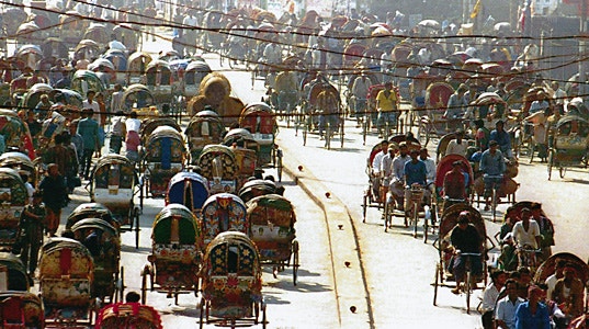 A street with many pedicabs in Dhaka