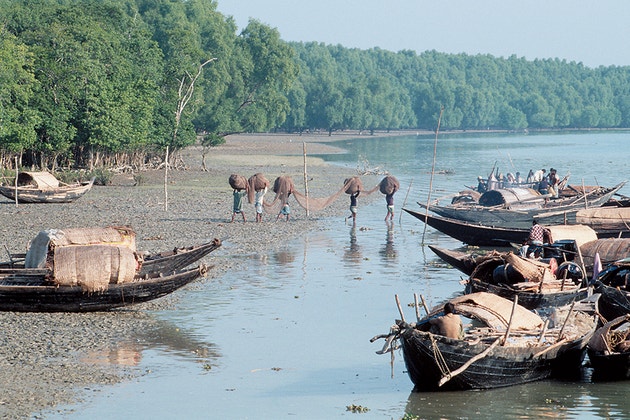 Boats on the shore line and people fishing